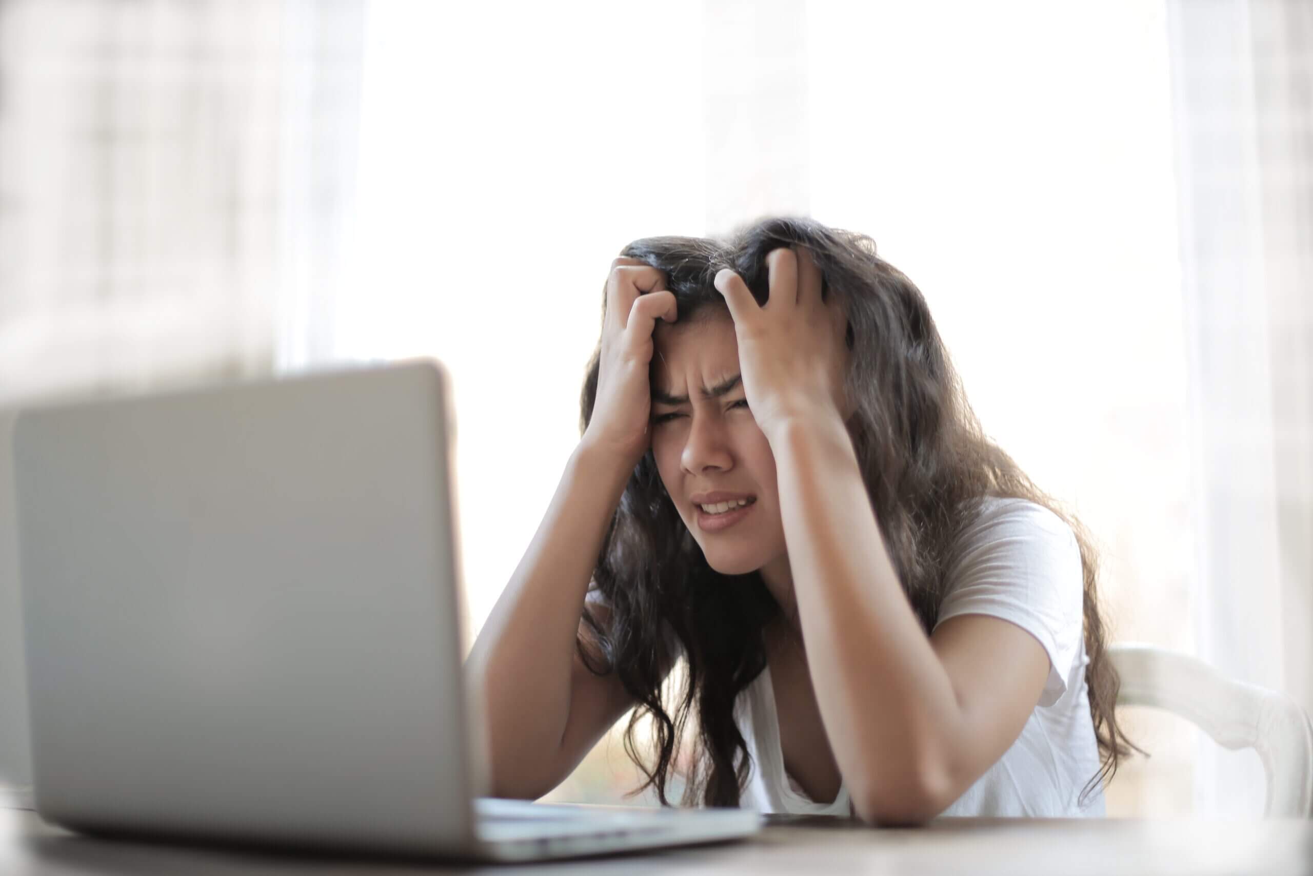 Frustrierte Frau sitz vor einem Laptop